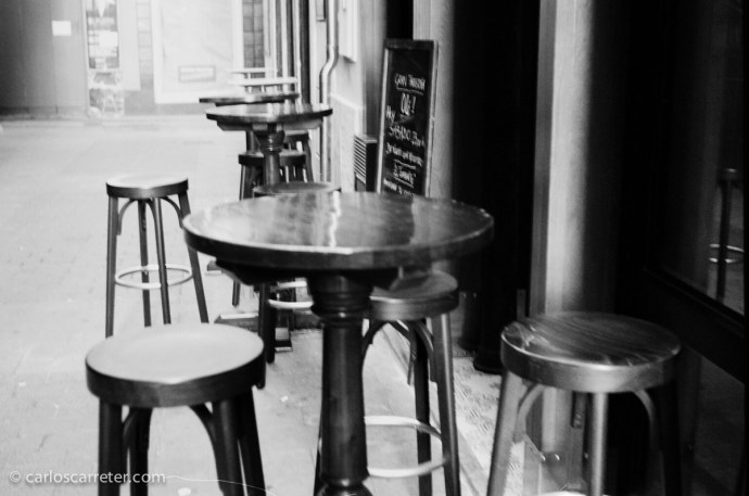 Mesas y banquetas en los bares del Tubo de Zaragoza. Fotografía tomada con una Zeiss Ikon Contessa 35 sobre negativo en blanco y negro cromogénico.