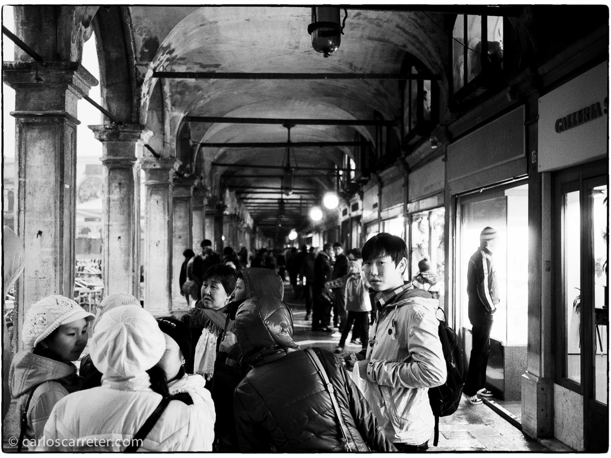 Turistas asiáticos en los soportales de la Piazza San Marco.