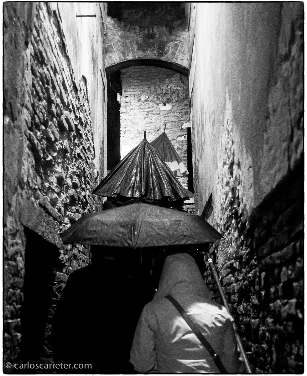 La dificultad para avanzar con el paraguas en alguno de los estrechos callejones que forman el dédalo de vías públicas de la ciudad de los canales.